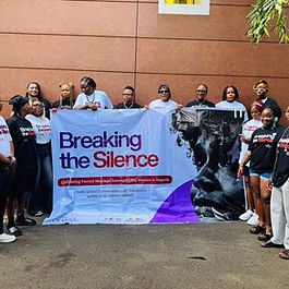 Group of women holding a banner that says "Breaking g the Silence"