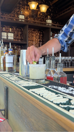 Bartender pouring a craft cocktail from The Heritage Wagon mobile bar.