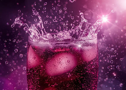 A glass of fizzy elderberry sparkler with ice, lemon slices, and fresh mint, showing a deep purple hue from elderberry syrup