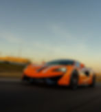 Picture of an Orange McLaren driving down the road