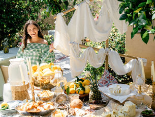 Monica Gisele standing beside an elegant outdoor cheese and citrus buffet table at a pirate themed birthday party in Los Angeles