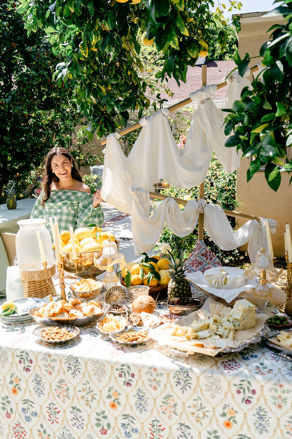 Monica Gisele standing beside an elegant outdoor cheese and citrus buffet table at a pirate themed birthday party in Los Angeles