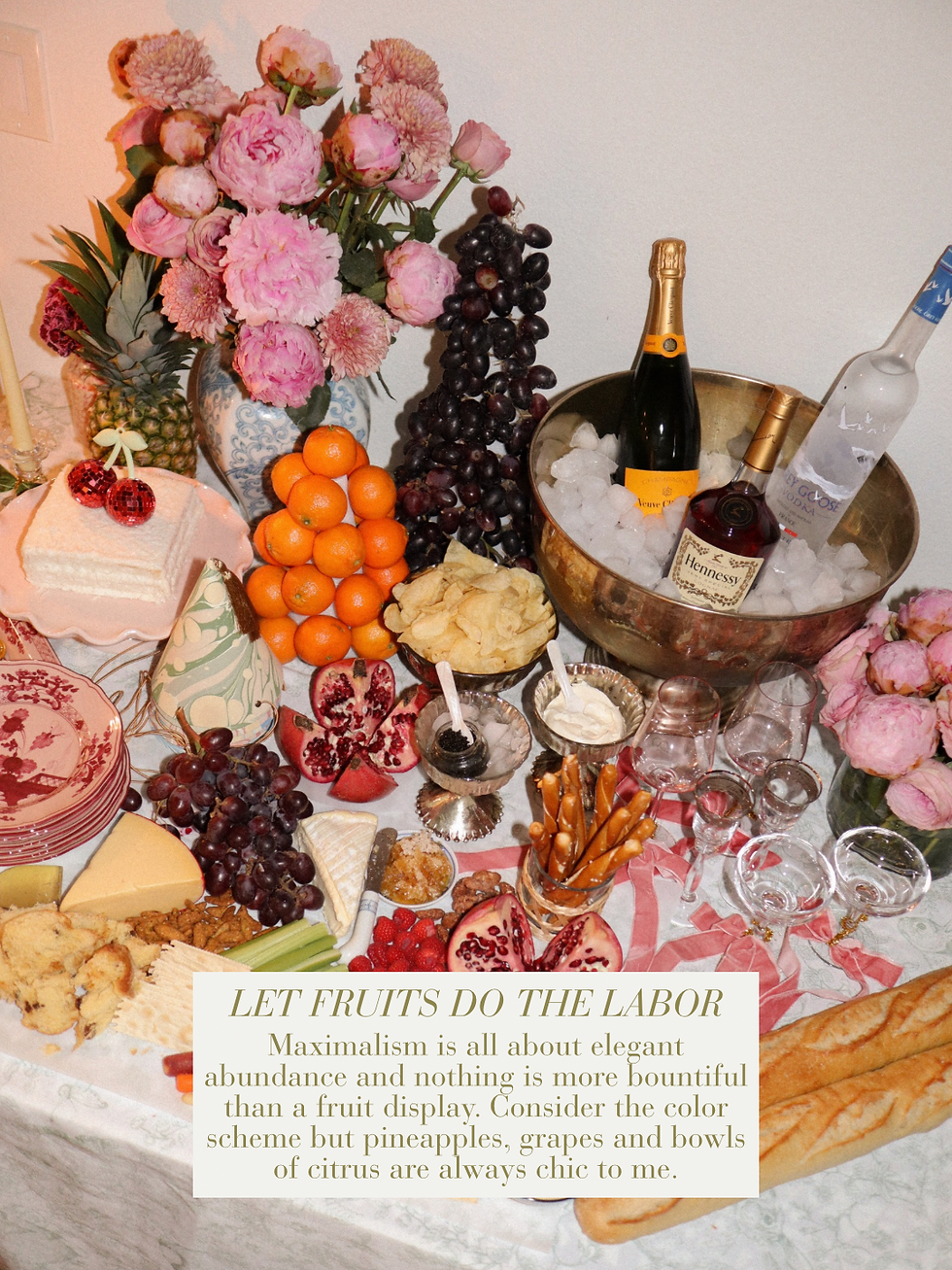 Abundant maximalist buffet table with pineapple, pomegranates, grapes, citrus and Veuve Clicquot champagne