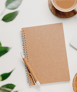 Aesthetic workspace, top view Notepad, laptop, coffee and office supplies with green leave