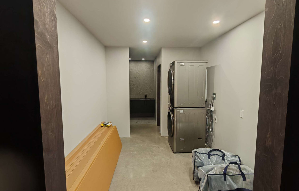 Travaux en cours dans une salle de lavage avec murs blancs, équipements au sol 