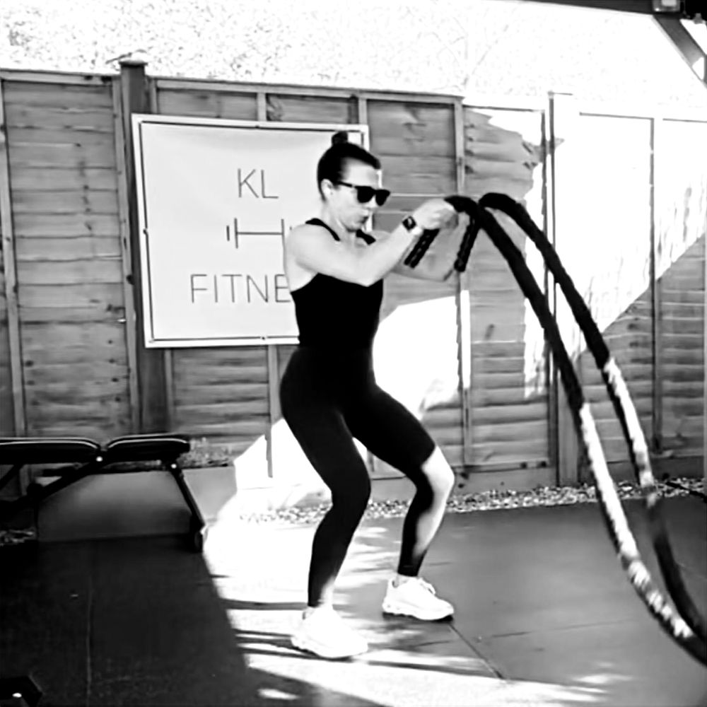 Fitness strength personal training women using battle ropes