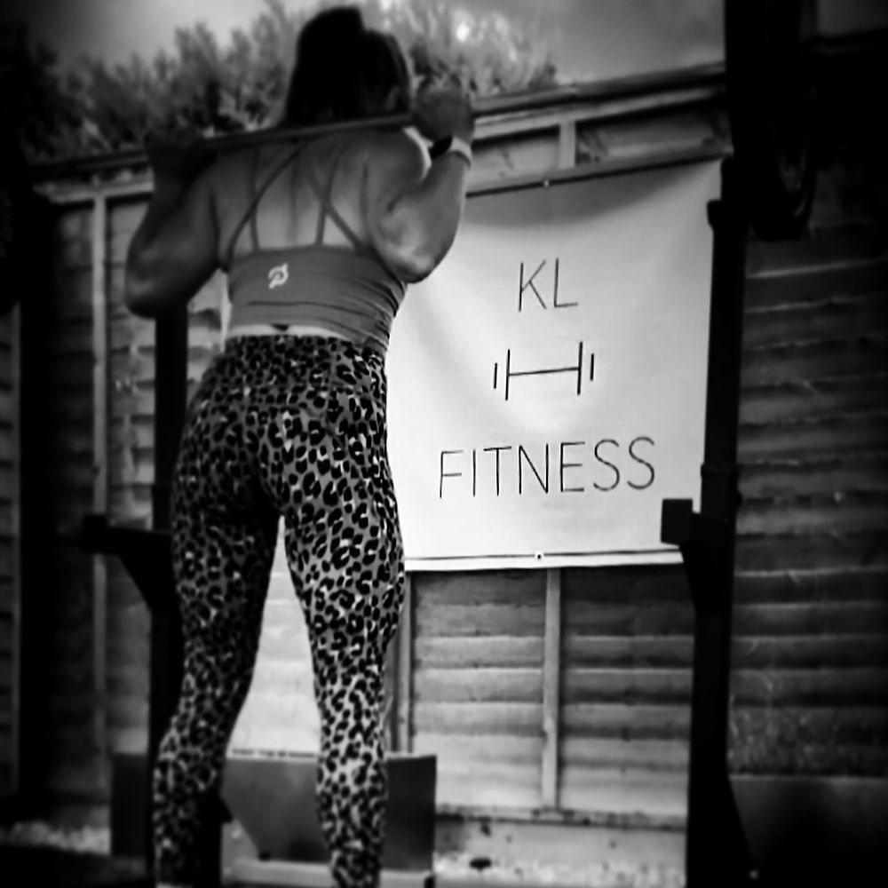 Woman doing barbell strength training at KL FITNESS