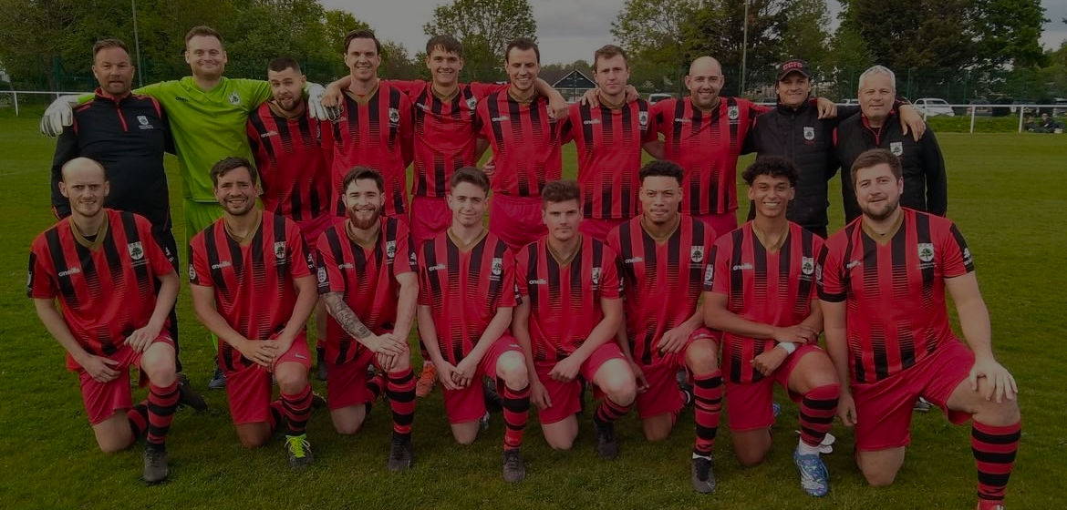An image of a Sunday League football squad dressed in red and black jerseys.