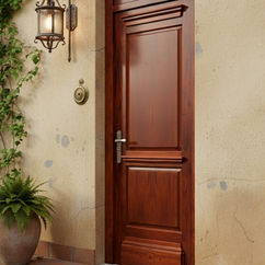 Puerta antigua de madera maciza instalada en fachada clásica.