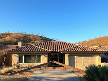 Single-family San Diego home with a tile roof and dry hillside brush nearby, illustrating wildfire and roof factors that affect home insurance.