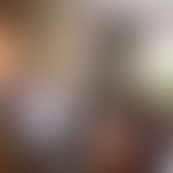 A woman balancing a laptop on a kitchen counter while holding a toddler, surrounded by herbal tea and spiritual oils, symbolizing the Divine Alchemist in the Triple Shift.