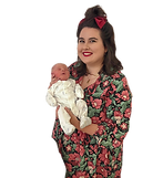 private midwife in floral outfit holding newborn