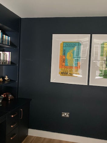 Interior wall with two framed ‘Admit One’ prints featuring Nirvana and The Verve, set against a dark blue backdrop.