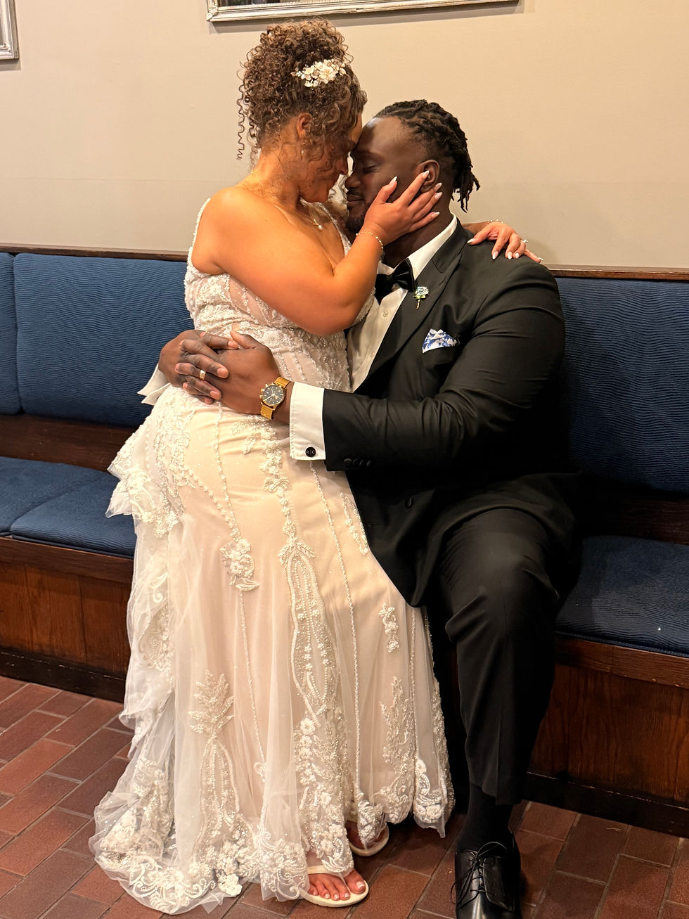 bride and groom embracing each other on blue couch
