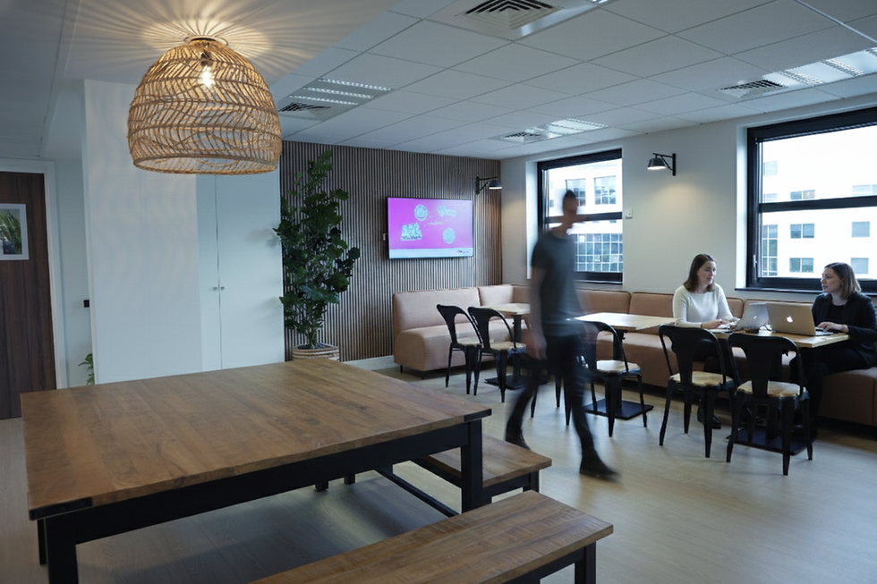 Espace informel avec assises conviviales et écran mural, conçu pour favoriser les échanges dans les bureaux IDEX à Rueil-Malmaison.