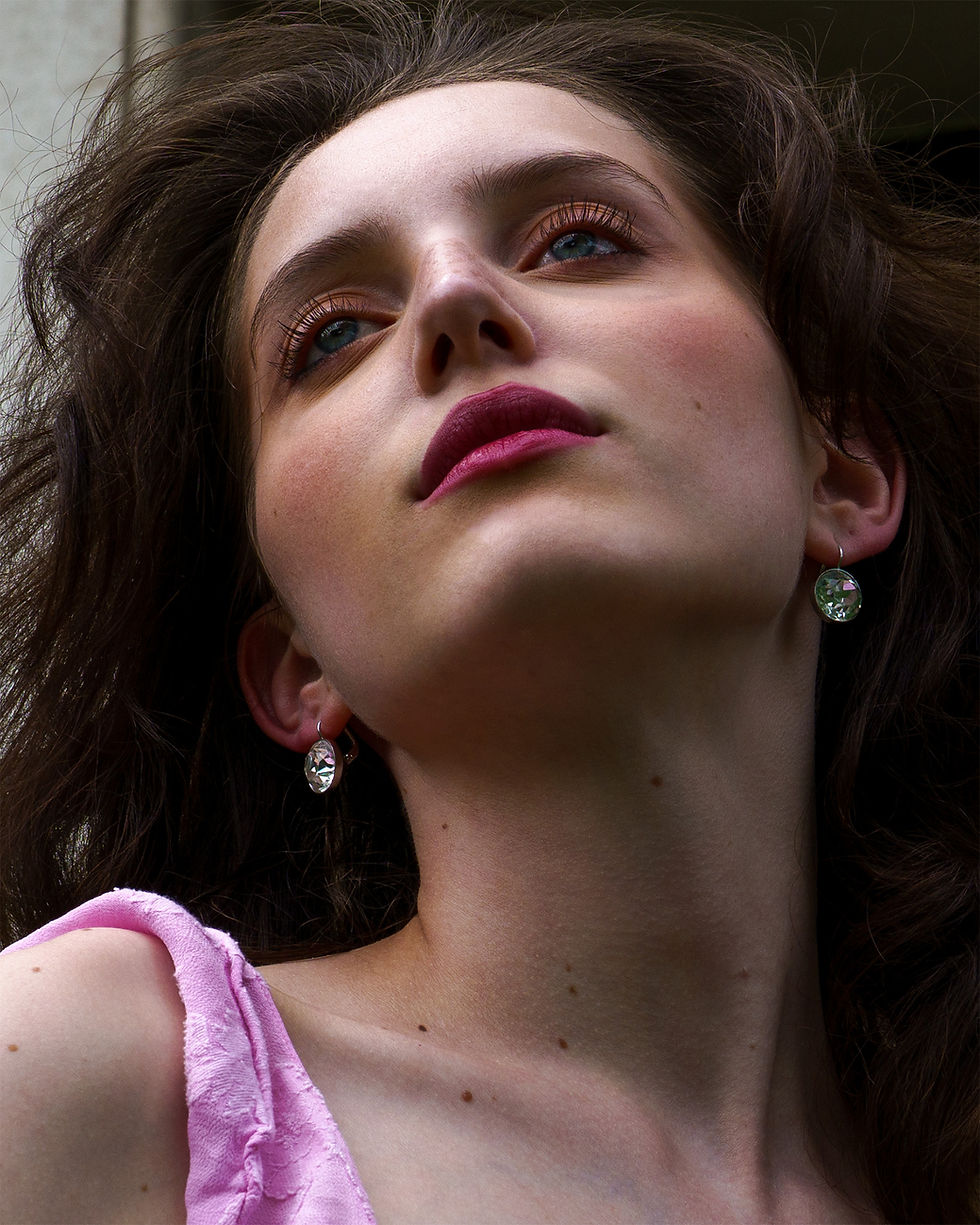 Close portrait of a woman looking up into the sky in soft natural light.