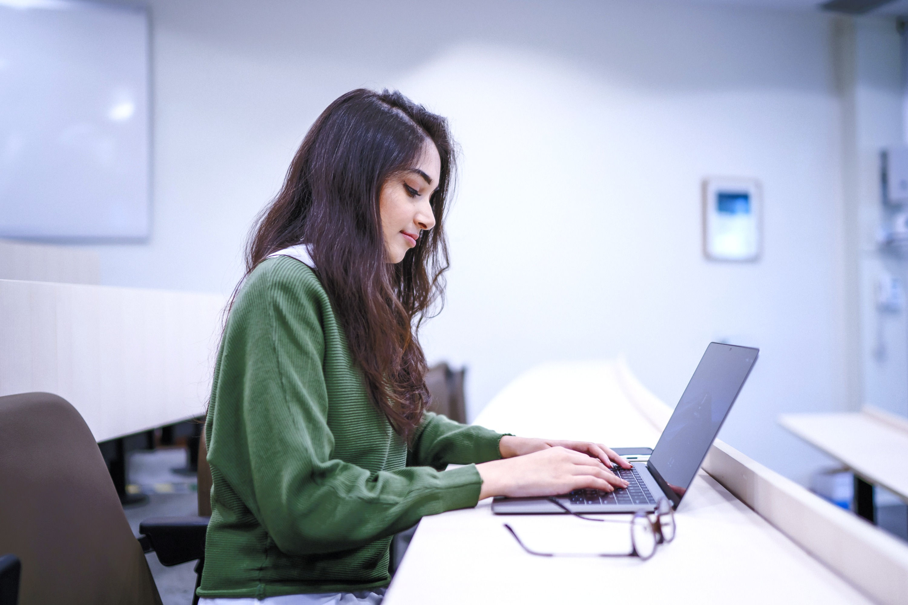a girl sitting and working on the computer