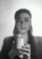 Editorial image of a woman holding a candle in front of her in her hands.