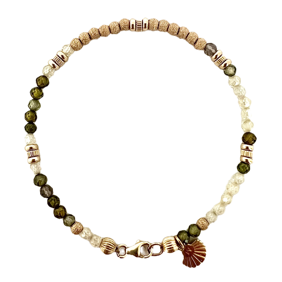 Necklace with shells, green stones and a tassel, neutral background.