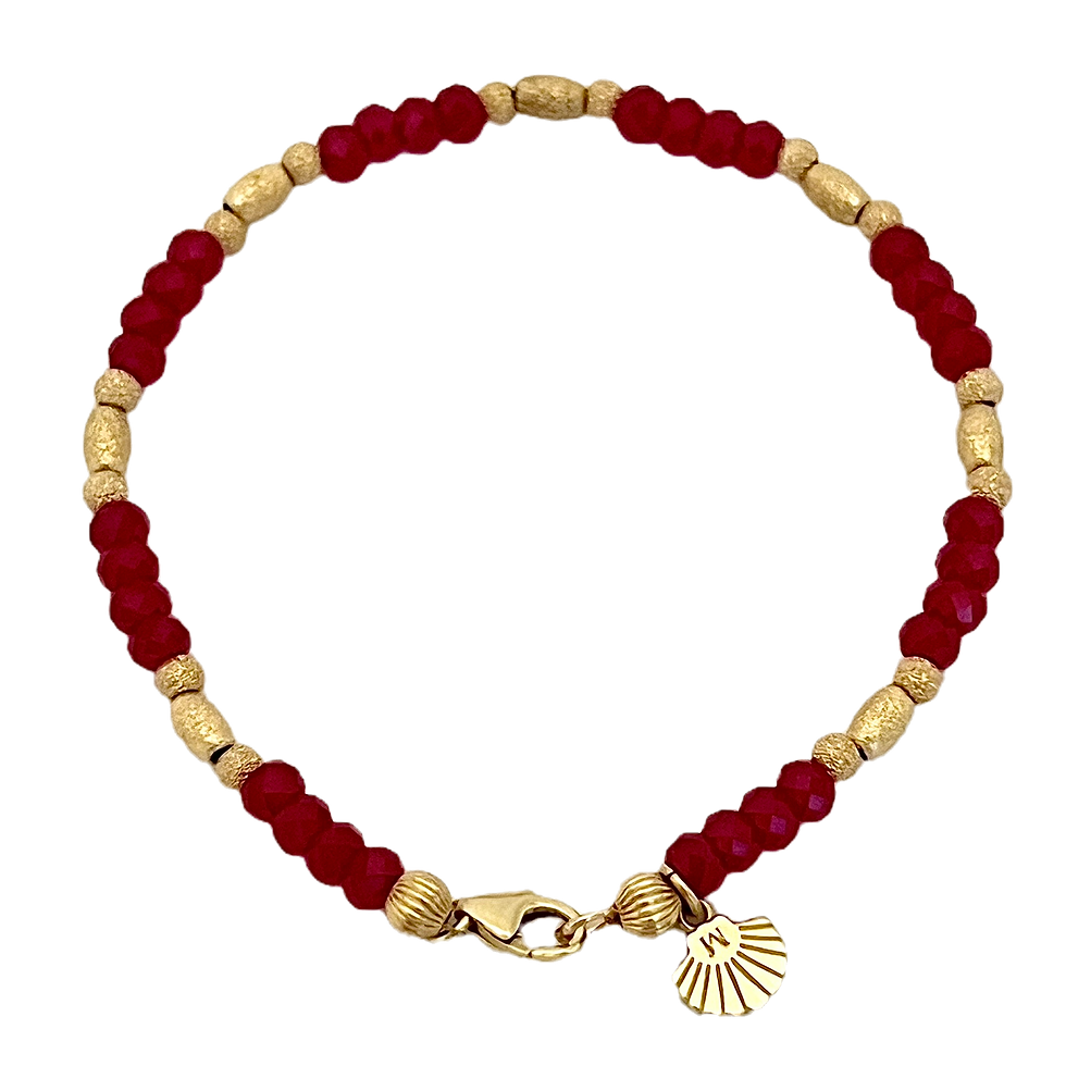 Red and gold beaded bracelet with a decorative charm on black background.