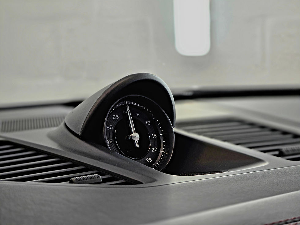 Black analog stopwatch recessed in a car dashboard, with 5–55 markings and a sleek gray interior.