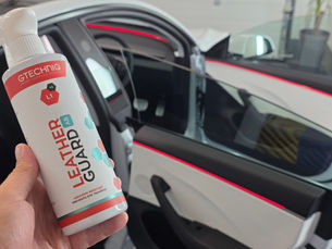 man holding gtechniq leather guard in the background you can see a clean white cars interior