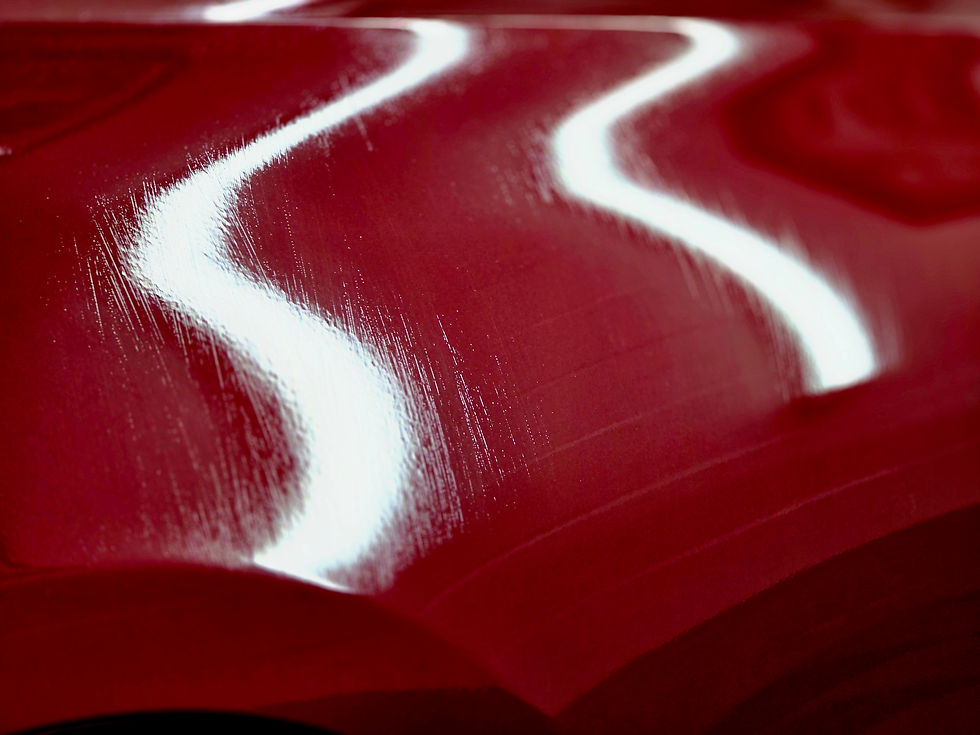 Abstract close-up of glossy red surface with white wavy reflections and brush-like streaks, creating a vivid, dynamic look