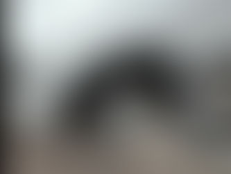 A alloy wheel being take off a white car with a car jack.