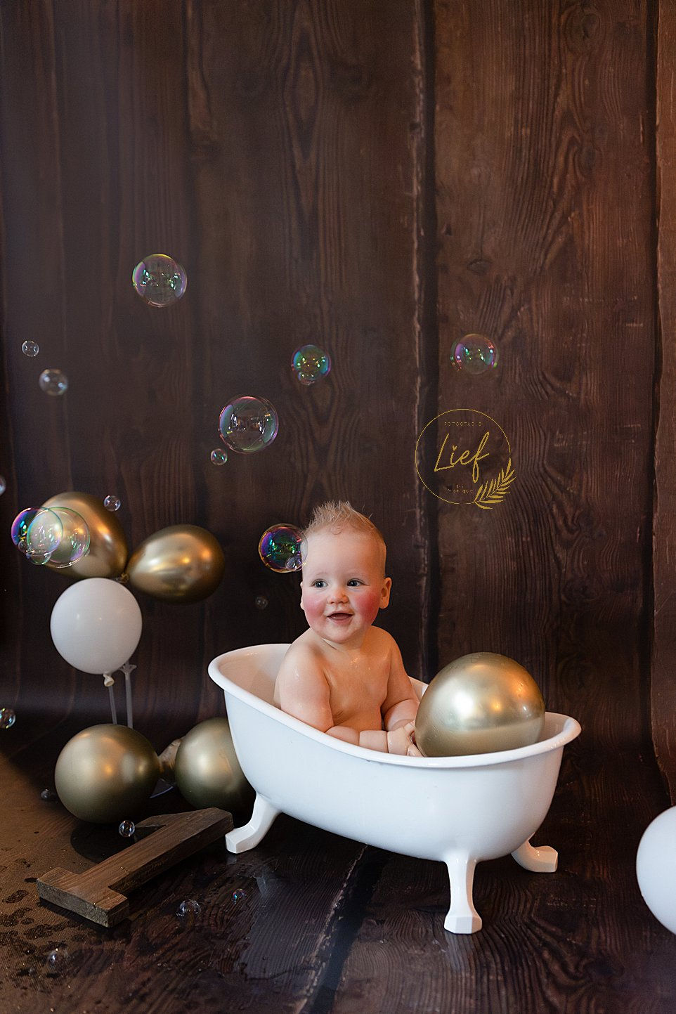 Baby lacht terwijl hij spettert in badje tijdens professionele fotoshoot