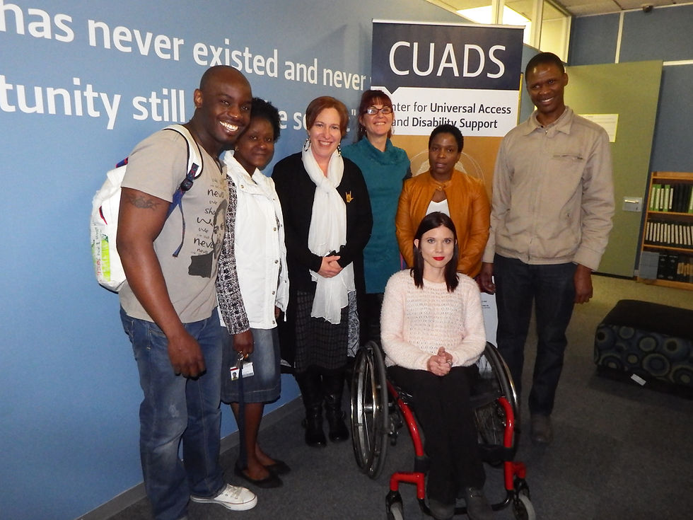 A group of people in front of a CUADS banner, one in a wheelchair