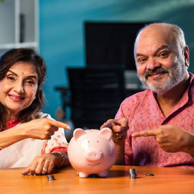 A couple points to their piggy bank after budgeting to tell others to save money