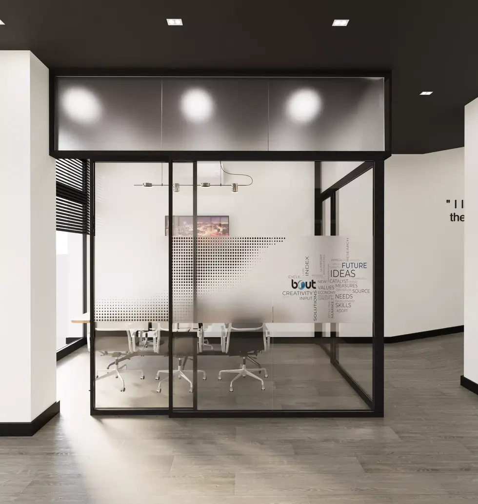 Conference room with wooden table and black chairs behind glass partition