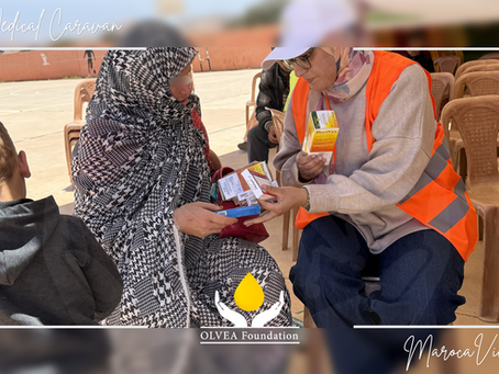 Medical caravan in Sidi Mbarek, Sidi Ifni, Morocco - healthcare volunteer from MarocaVie and OLVEA Foundation providing medication to a local patient during a rural healthcare outreach initiative, improving access to medical services in isolated communities.