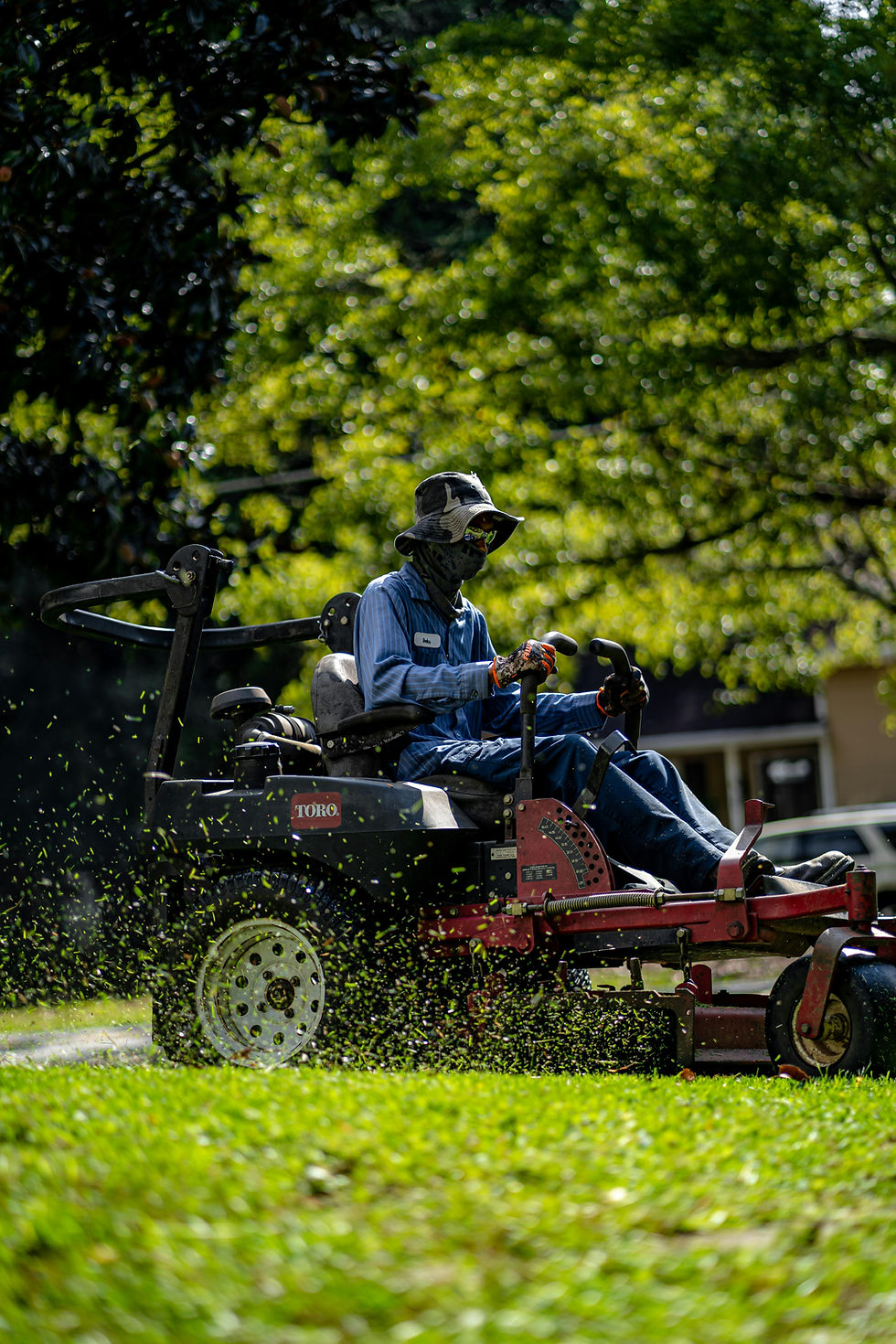lawn care technician riding a lawn mower