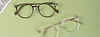 two pairs of glasses frame lay on a green background