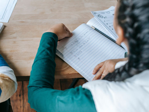 Girl in classroom doing math in workbook