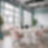 Cozy office with one conference table with computers for 5 employees in the midddle of the
