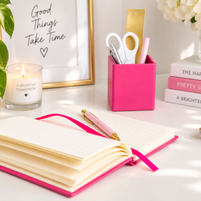 Pink leather notebook and matching pen pot, handcrafted in England and styled together as colourful desk accessories.