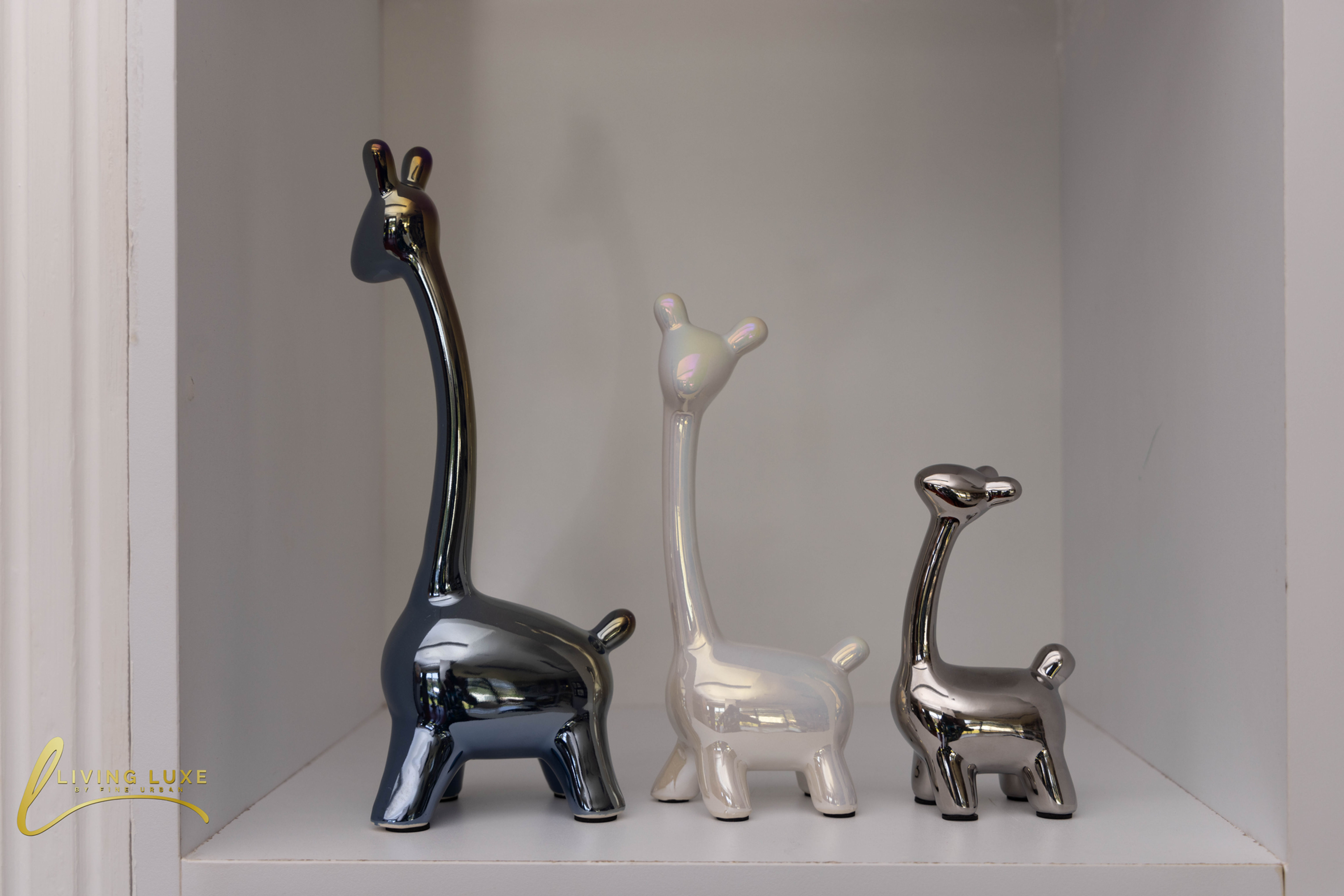 Set of three ceramic giraffe figurines (black, white, silver) from The Living Luxe, Karen, for home decor.