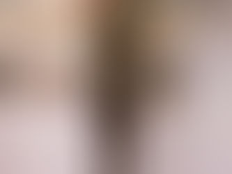 A textured bronze sculpture stands gracefully before a stylishly curated shelf, showcasing art deco elements and various decorative objects.