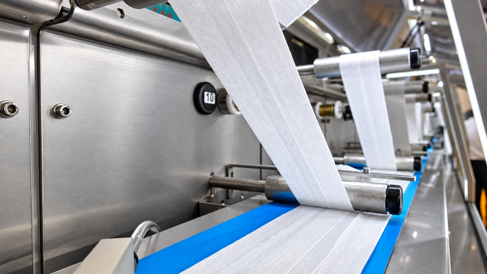 Nonwoven sheet passing through wet wipes production equipment