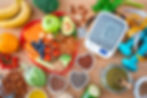 An image showing fruits and vegetables, exercise weights, a blood pressure meter and stethoscope. 