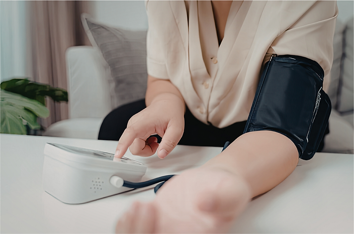 A person uses a blood pressure monitor to check their blood pressure.