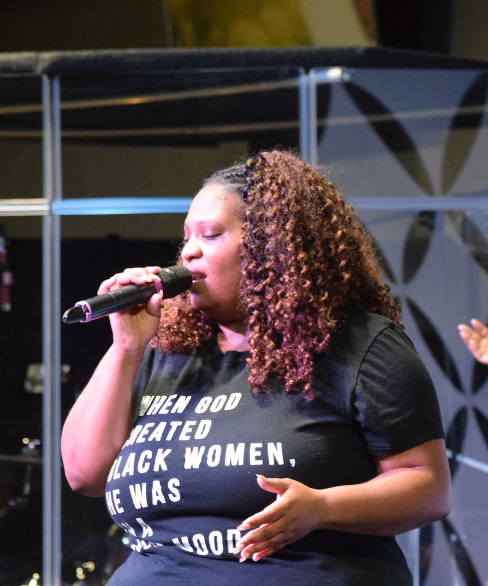 A young lady singing in worship in Springfield, MA