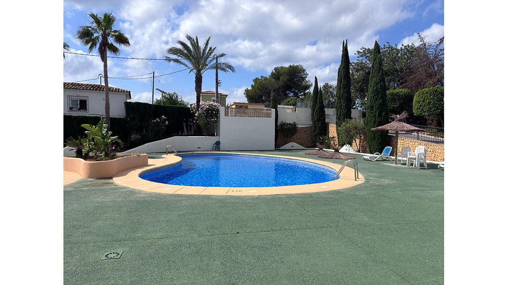 Outdoor pool at a holiday bungalow calpe with palm trees