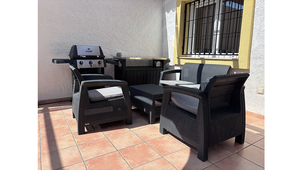 Outdoor patio with seating and BBQ at a holiday bungalow Calpe