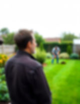 A home owner watching a gardener lawning