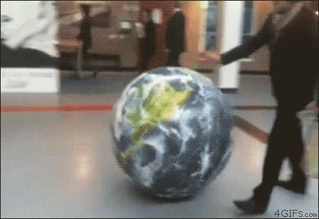 A man kicks a large ball designed to look like the Earth. It hits a small child and knocks them over.