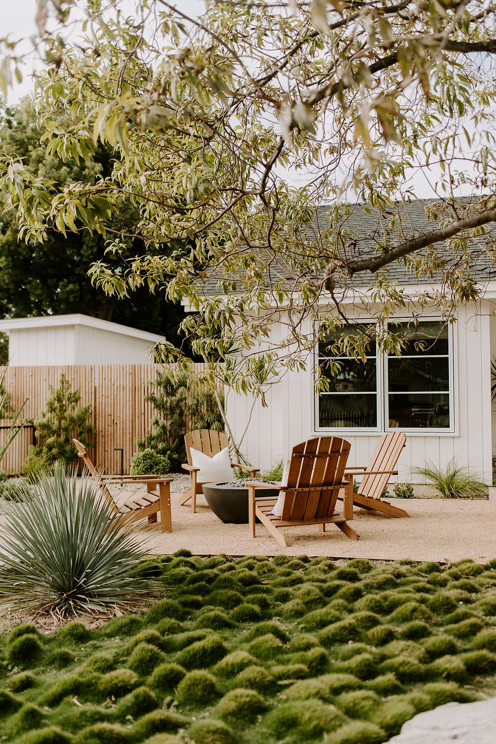 Front yard entertaining area with a modern lawn alternative and fire pit area.