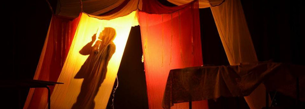 Godchekov, the circus owner contemplating to murder Patal, 'The hunger artist' behind a tent. An adaptation of Franz Kafka's 